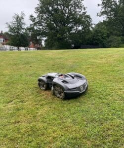 Lightweight robot lawn mower cutting in the rain on a steep bank